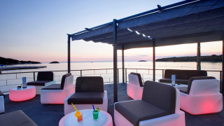 Buitenlounge met moderne zitplaatsen en uitzicht op zee bij zonsondergang bij Camping Orsera in Istrië, Kroatië.