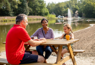 Famille sur la terrasse, table de pique-nique près de l'étang de baignade - Baalse Hei - Turnhout, Anvers, Belgique