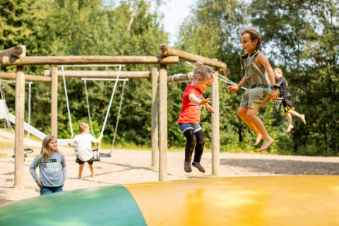 Kinderen spelen en springen op een springkussen in de buitenlucht bij vakantiepark Baalse Hei in Antwerpen.