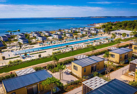 Camping Arena Grand Kažela in Istria, Croazia, con bungalow moderni, piscina lunga e vista panoramica sul mare.