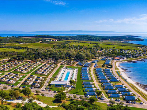 Vista aérea del Camping Arena Grand Kažela con casas móviles, piscina y la costa en Istria, Croacia.