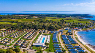 Luftfoto af Camping Arena Grand Kažela-feriepark med hytter, pool og udsigt over kysten i Istrien, Kroatien.