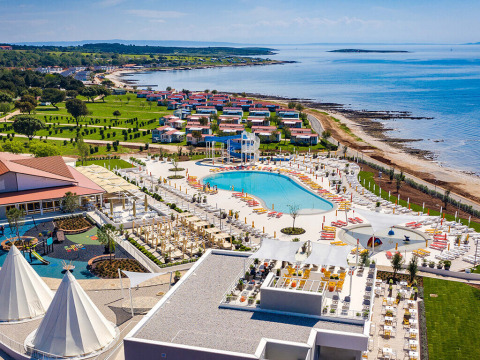 Camping Arena Grand Kažela, parco vacanze in Istria, Croazia, con piscina, spiaggia e bungalow colorati.