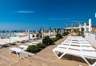 Terrazza solarium con lettini e ombrelloni presso la piscina di Camping Arena Grand Kažela, Istria, Croazia.