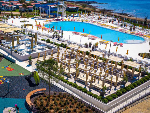 Vista aerea di Camping Arena Grand Kažela in Istria, Croazia, con piscina, lettini e vista mare.