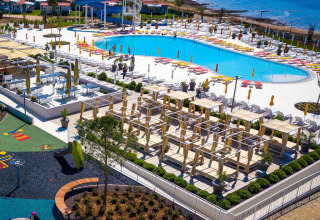 Vista aerea di Camping Arena Grand Kažela in Istria, Croazia, con piscina, lettini e vista mare.