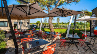 Udendørs spiseområde med farverige stole og parasoller på Camping Arena Grand Kažela, Istrien, Kroatien.