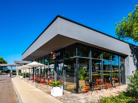 Moderne café met buitenterras en parasols bij Camping Arena Grand Kažela in Istrië, Kroatië.