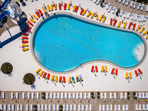 Aerial view of a pool with colorful sun loungers at Camping Arena Grand Kažela holiday park in Istria, Croatia.