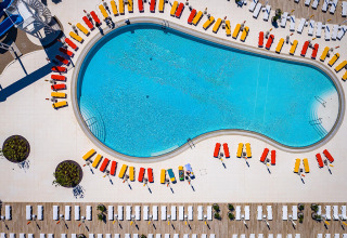 Aerial view of a pool with colorful sun loungers at Camping Arena Grand Kažela holiday park in Istria, Croatia.