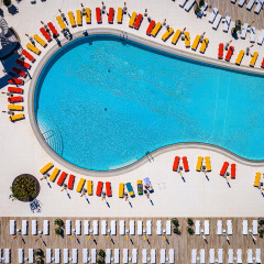 Luftfoto af swimmingpool med farverige liggestole ved Camping Arena Grand Kažela feriepark i Istrien, Kroatien.