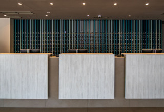 Modern reception with three counters and stylish backdrop at Camping Arena Grand Kažela, Istria, Croatia.