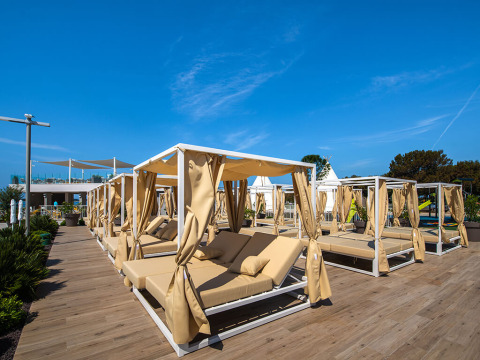 Outdoor lounge area with canopy daybeds and sun loungers at Camping Arena Grand Kažela in Istria, Croatia.
