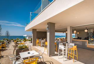 Outdoor dining area at Camping Arena Grand Kažela in Istria, Croatia, with beautiful sea views.