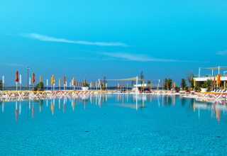 Large swimming pool with sun loungers and colorful umbrellas at Camping Arena Grand Kažela in Istria, Croatia.