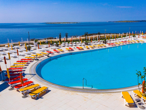 Large pool area at Camping Arena Grand Kažela in Istria, Croatia, with sun loungers and sea view.