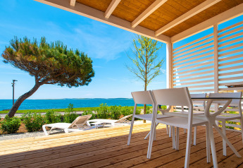 Udsigt fra træterrasse ved Camping Home Next, Camping Arena Grand Kažela, Kroatien med hav og liggestole.
