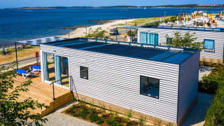 Chalet Camping Villa First Row en bord de mer, extérieur moderne en bois, terrasse et vue sur la plage.