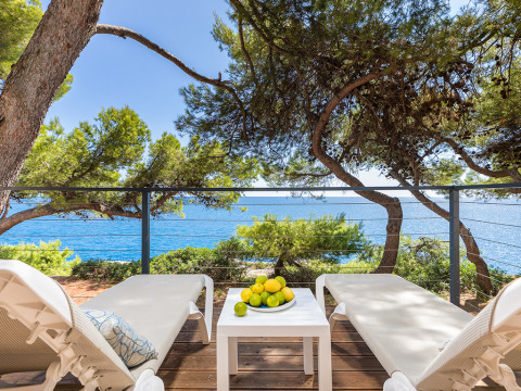 Zonneterras met twee ligstoelen, tafel met citroenen en zeezicht bij Camping Arena Stoja in Kroatië.