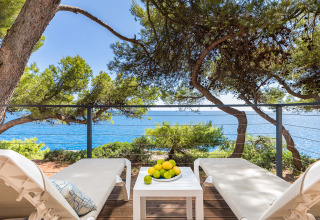 Terrazza soleggiata con due lettini, tavolo con limoni e vista mare al Camping Arena Stoja, Croazia.