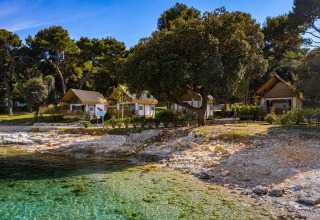 To-værelses glamping safari-lofttelt ved Camping Arena Stoja i Kroatien med udsigt over klart vand.