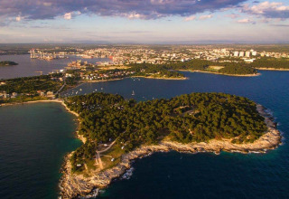 Aerial view of Camping Arena Stoja holiday park in Istria, Croatia, surrounded by trees and the blue sea.