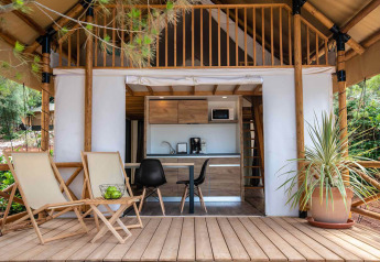 Tienda de glamping safari con dos dormitorios, terraza de madera y asientos en Camping Arena Stoja, Croacia.