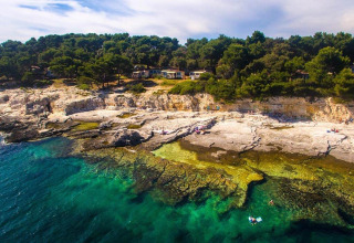 Aerial view of Camping Arena Stoja in Istria, Croatia, featuring rocky shorelines and turquoise water.