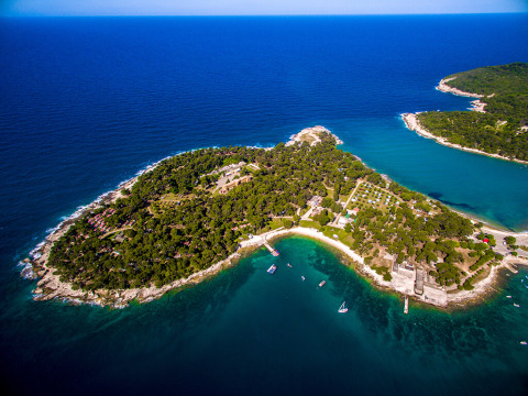 Luchtfoto van vakantiepark Camping Arena Stoja op een groene landtong aan het heldere zeewater in Istrië, Kroatië.
