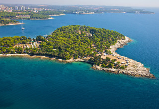 Vista aerea del Camping Arena Stoja in Istria, Croazia, circondato da alberi verdi e dal mare turchese.