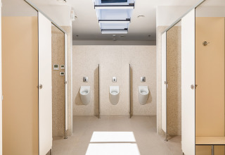 Bagno pubblico moderno con orinatoi e cabine nel Camping Arena Stoja, parco vacanze in Istria, Croazia.