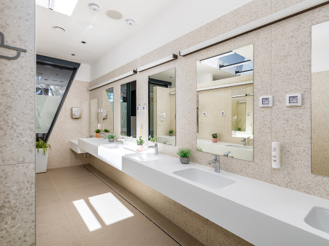 Bagno moderno e luminoso al Camping Arena Stoja in Istria, Croazia, con grandi specchi e piante decorative.