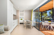 Modern lodge at Camping Villa Sea View, Arena Stoja, Croatia, featuring terrace and sea view through trees.
