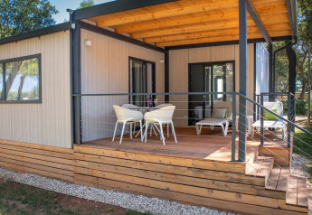 Wooden deck with seating outside the Deluxe Camping Villa at Camping Arena Stoja in Croatia.