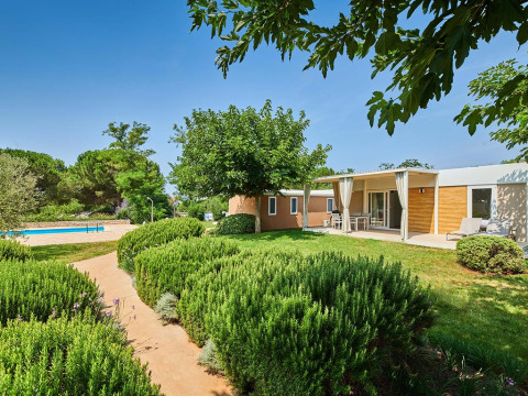 Moderne bungalow met terras en zwembad omringd door groen op Camping Park Umag, Istrië, Kroatië.