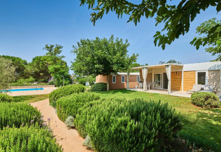 Moderne bungalow met terras en zwembad omringd door groen op Camping Park Umag, Istrië, Kroatië.
