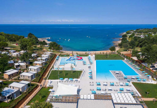 Vista aerea del Camping Park Umag in Istria, Croazia, con piscine, bungalow e vista sul mare.