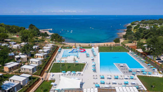 Luftfoto af Camping Park Umag i Istrien, Kroatien med pool, hytter og udsigt over havet.