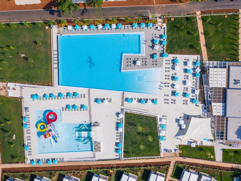 Aerial view of Camping Park Umag in Istria, Croatia, featuring large pools, sunbeds, slides and green areas.