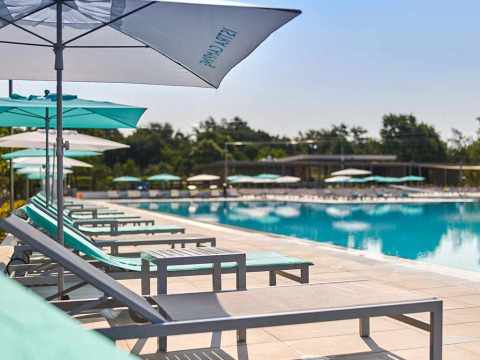 Tumbonas y sombrillas junto a la piscina en Camping Park Umag, un parque vacacional en Istria, Croacia.