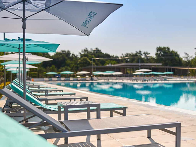 Ligstoelen en parasols bij het zwembad van Camping Park Umag, een vakantiepark in Istrië, Kroatië.