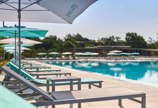 Zonovergoten ligstoelen en parasols bij het zwembad van Camping Park Umag, vakantiepark in Istrië, Kroatië.