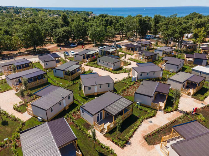 Luchtfoto van moderne huisjes op Camping Park Umag in Istrië, Kroatië, dicht bij zee en omgeven door groen.