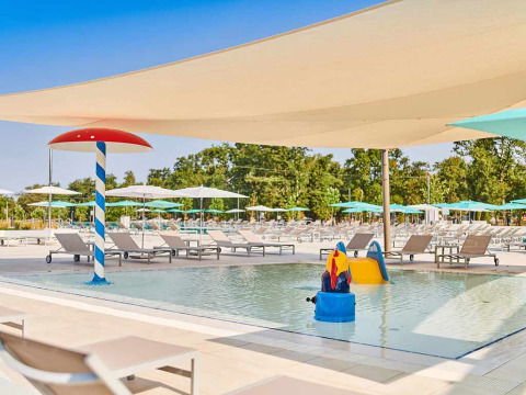 Kinderfreundlicher Pool mit Liegen, Sonnenschirmen und Wasserspielplatz im Camping Park Umag, Istrien, Kroatien.