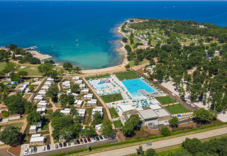 Aerial view of Camping Park Umag in Istria, Croatia, featuring pools, cabins, and a scenic coastline.