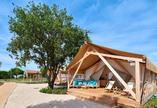 Tenda glamping con veranda in legno al Camping Park Umag, villaggio vacanze in Istria, Croazia, cielo sereno.