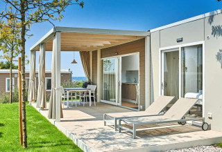 Modern holiday accommodation with terrace and sun loungers at Camping Park Umag, Istria, Croatia, on a sunny day.