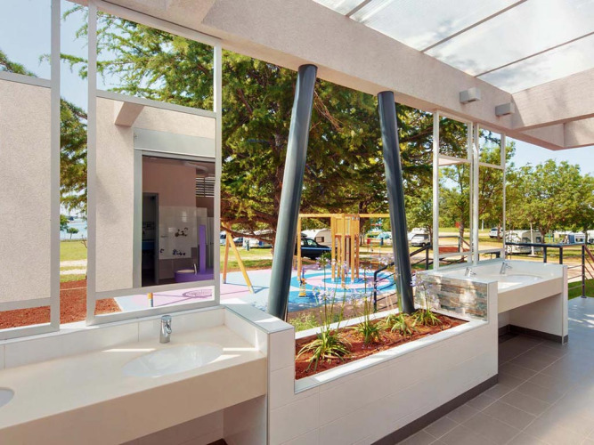 Moderne buitenwastafels met uitzicht op speeltuin en groen bij Camping Park Umag, Kroatië.