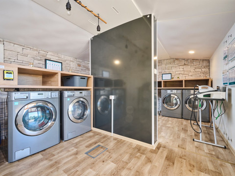 Modern laundry room at Camping Park Umag in Istria, Croatia, featuring washing machines and wood floors.