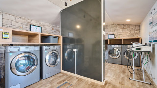 Moderne vaskerum på Camping Park Umag i Istrien, Kroatien med vaskemaskiner og trægulv.